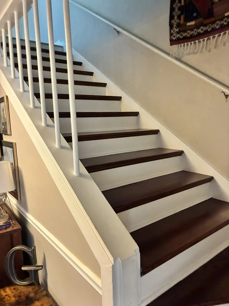 A staircase with dark wood treads, white risers and white balusters